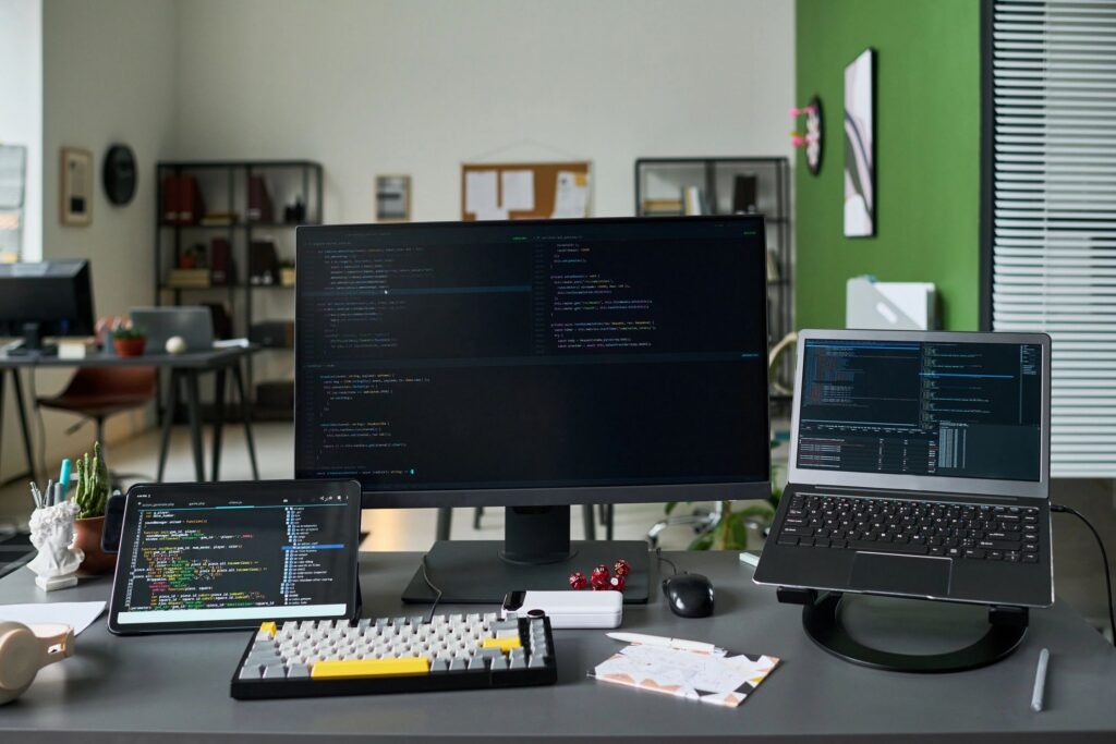Software development workspace with code displayed across multiple monitors
